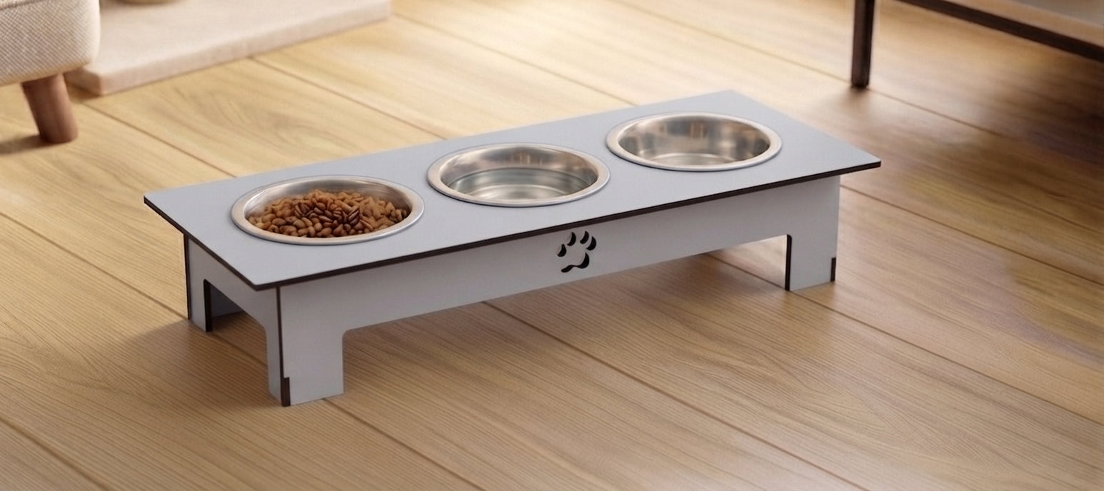 A light gray wooden elevated pet feeder with three bowls (two stainless steel, one filled with kibble) on a light wood floor.