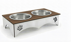 An elevated double pet feeder and water bowl stand made of brushed stainless steel with a dark brown wood-grain top surface. The stand features paw print cutouts on the sides and two integrated stainless steel bowls on a white background.