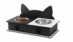 A black cat-shaped elevated pet feeder and water bowl stand with stainless steel bowls, one filled with dry food, shown on a white background.
