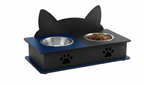 A black cat-shaped elevated pet feeder with a blue base and two bowls, one stainless steel and one filled with pet food, shown on a white background.