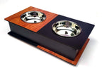 A dual pet feeder and waterer station with a wood-grain and black laminate base, featuring two stainless steel bowls, shown on a white background.