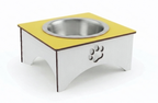 A square elevated pet food bowl stand with a yellow top surface, a stainless steel bowl, and a white base featuring a paw print cutout, shown on a white background.