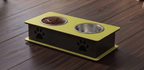 A two-bowl pet feeder and waterer elevated platform on a dark wood floor. The platform features a bright yellow top and base with black sides decorated with black paw prints, holding a bowl of dry food and an empty stainless steel bowl.