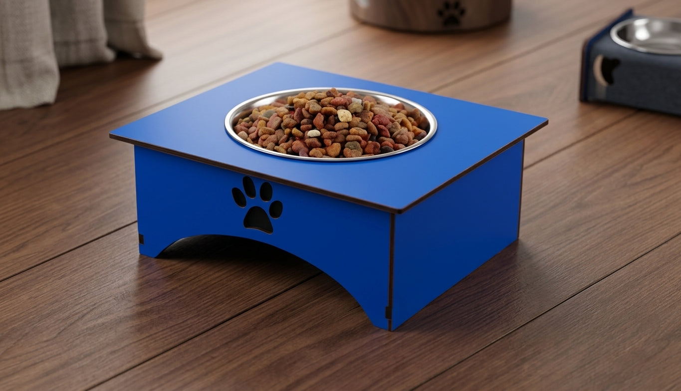 A blue elevated pet feeder with a stainless steel bowl filled with dry kibble, placed on a wooden floor. The feeder has a black paw print cutout on the front.
