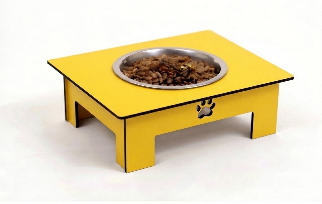 A yellow elevated pet feeder table with a stainless steel bowl filled with dry kibble, shown on a plain white background.