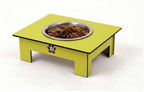 A bright yellow elevated pet feeder table with a stainless steel bowl filled with dry kibble, shown on a clean white background.