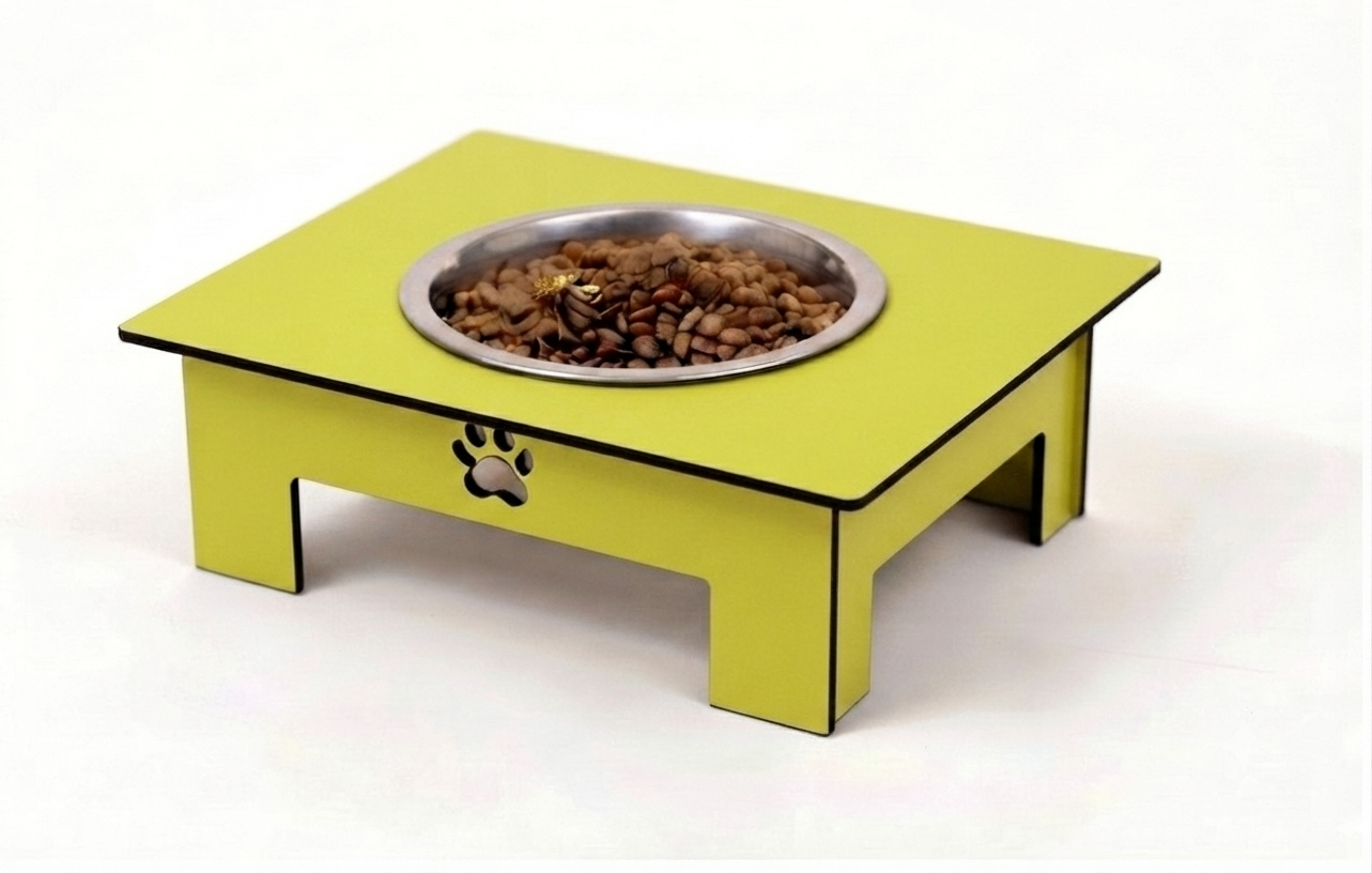 A bright yellow elevated pet feeder table with a stainless steel bowl filled with dry kibble, shown on a clean white background.