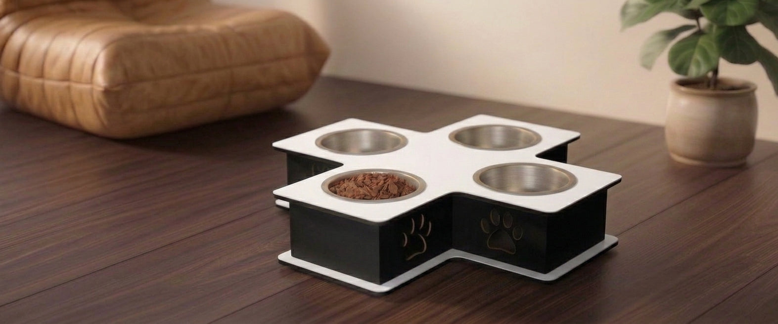 A four-compartment elevated pet feeder and water bowl stand with stainless steel bowls, shown on a dark wooden table in a home setting.