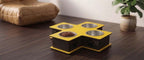 A pet elevated feeder and water bowl stand with a yellow and black design, featuring three bowls (two stainless steel, one with food) on a dark wooden table.