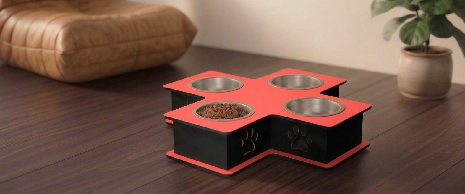 A 4-bowl pet feeder and water fountain elevated feeder with a red and black cross-shaped base, featuring stainless steel bowls and a bowl filled with dry food, set on a dark wooden table in a home environment.