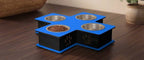 A pet feeder and waterer stand with four bowls, featuring a blue top platform, black base, stainless steel bowls, and a bowl of wet food, placed on a dark wooden table.