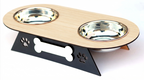 A two-bowl pet feeder and waterer stand with a light wood-grain top, two stainless steel bowls, and a black metal base featuring paw print and bone cutouts.