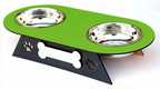 A two-bowl pet feeder and waterer stand with a bright green top tray, stainless steel bowls, and a black triangular base decorated with a bone and paw print cutout.
