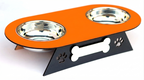 An elevated double pet food bowl set featuring a bright orange top tray with two stainless steel bowls, supported by a black metal stand with a bone-shaped cutout and paw print details.