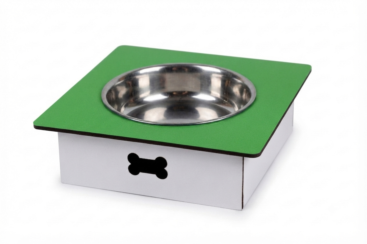 A square elevated pet feeder and water bowl stand with a green top platform, a stainless steel bowl, and a white base with a black bone-shaped cutout, shown on a white background.
