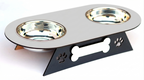 A two-bowl pet feeder and waterer elevated on a black metal stand with bone and paw print cutouts, featuring shiny stainless steel bowls on a white background.