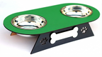 A pet feeder and waterer double bowl stand with a green top plate, two stainless steel bowls, and a black metal base with bone and paw print cutouts.