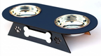 A black elevated pet feeder and water bowl stand with two stainless steel bowls, featuring a bone-shaped handle cutout and paw print details on the front.
