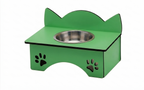 A green elevated pet feeder and water bowl stand with a stainless steel bowl, featuring cat-ear shaped backrests and paw print cutouts on the front, shown on a white background.