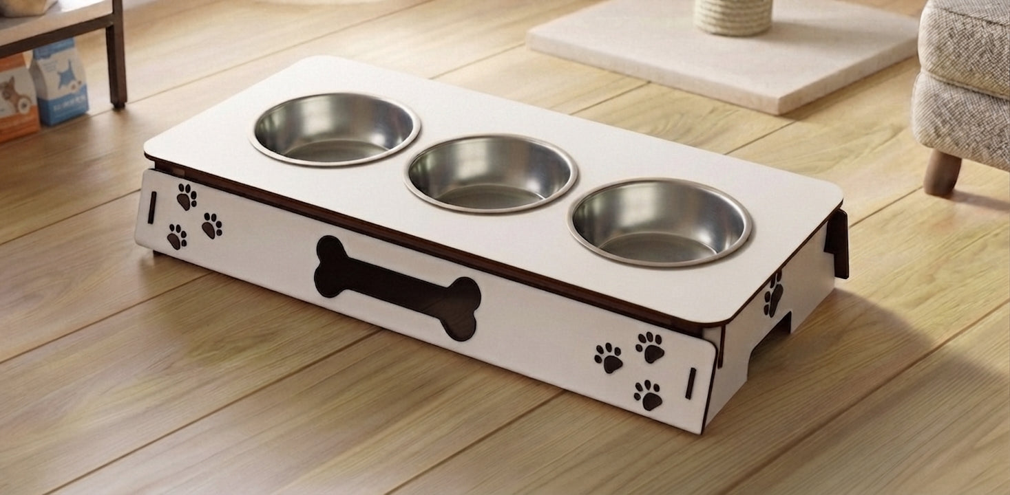 A three-bowl elevated pet feeder and waterer with a white wooden base, black paw print and bone graphics, and stainless steel bowls, shown on a light wood floor.